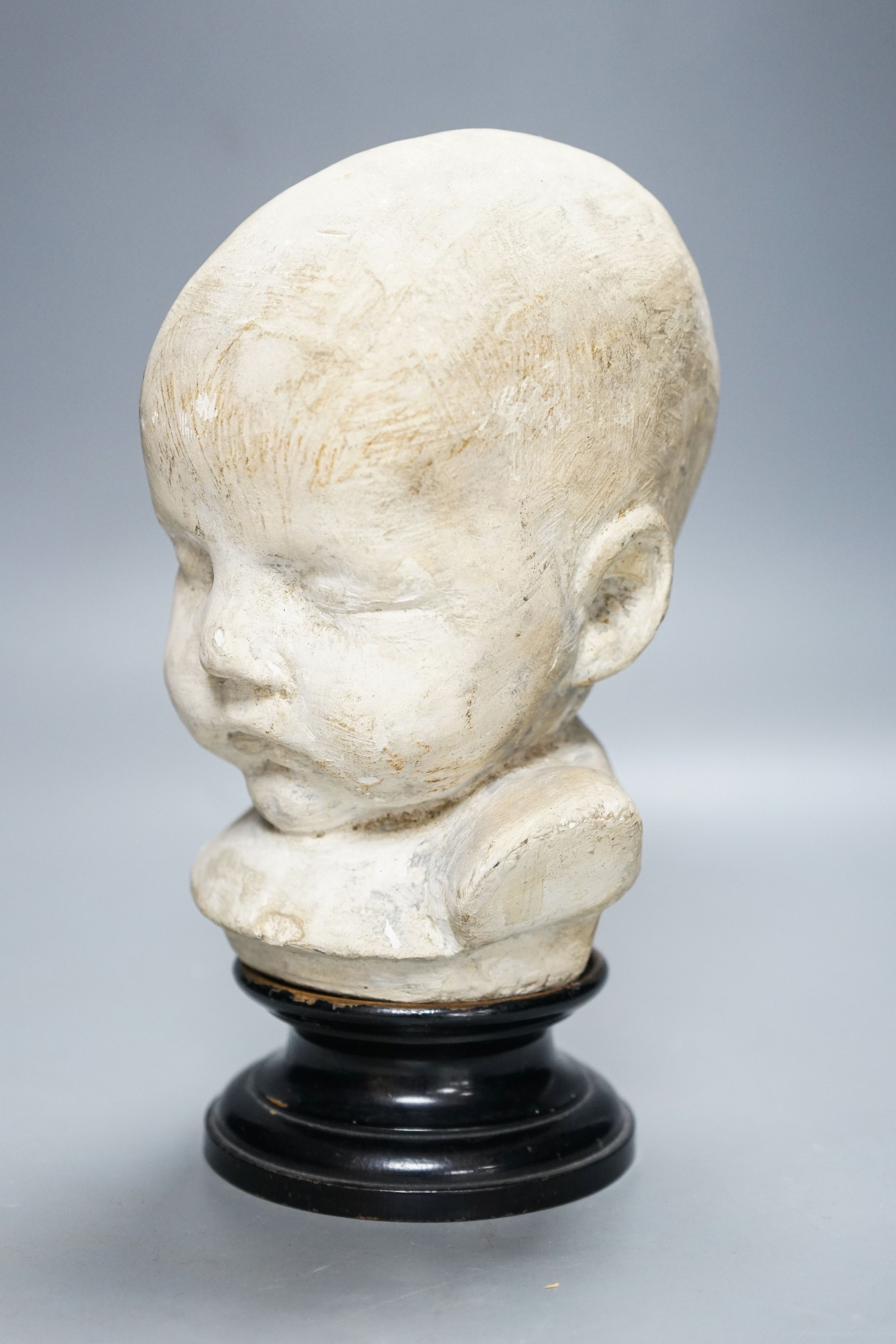 A 19th century memento mori plaster bust of an infant, on ebonised socle 22cm